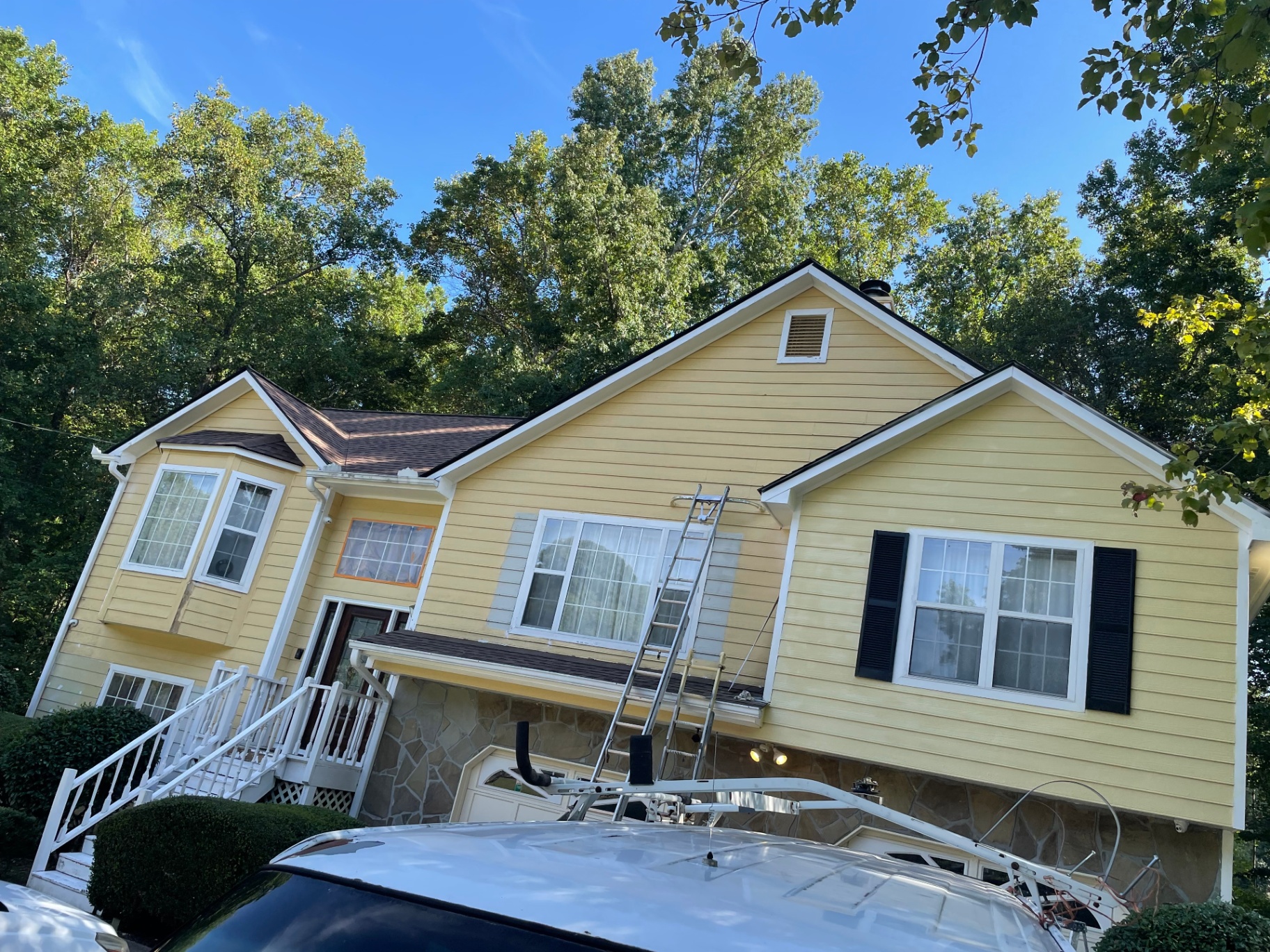 Exterior repaint and siding repair on yellow Craftsman-style home