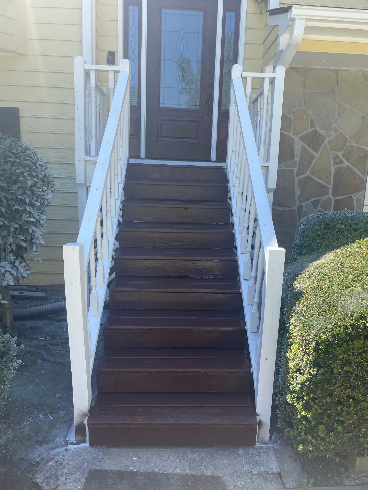 Front entry stairs refinished with rich mahogany stain and fresh white railings