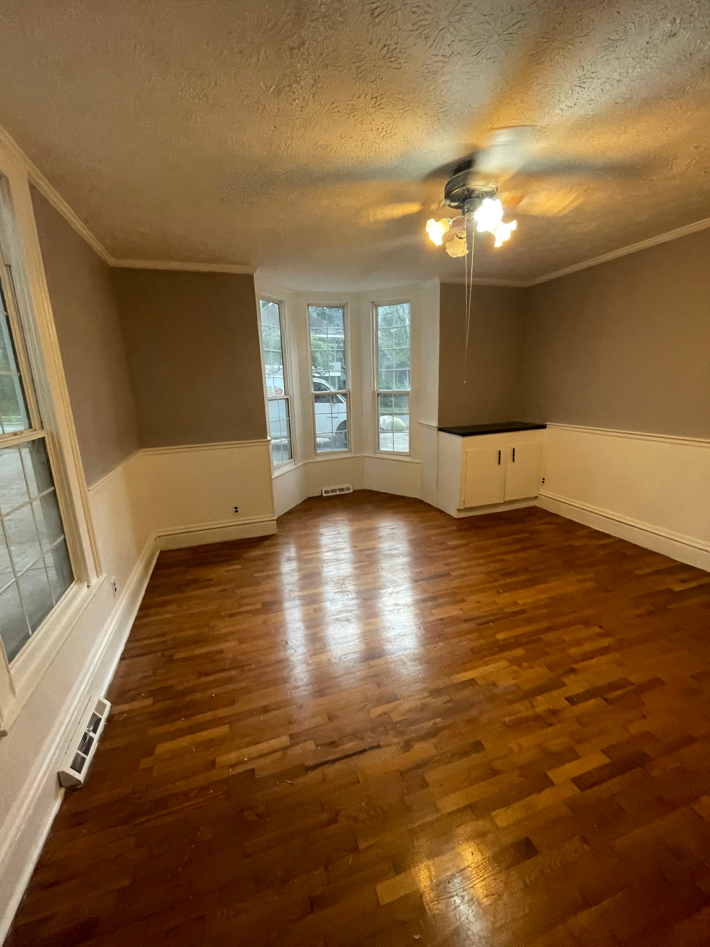 Interior living room with bay window and refinished hardwood floors