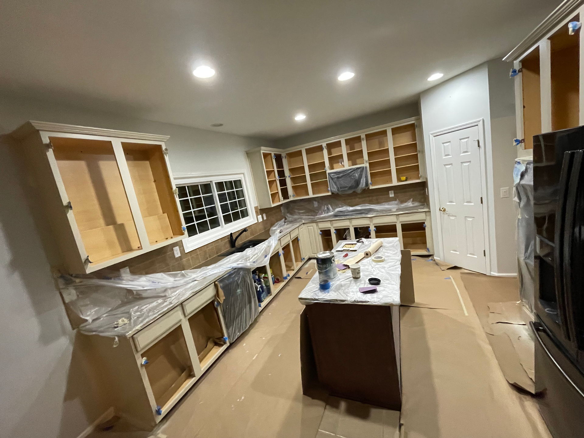 Kitchen cabinets prepped and masked off mid-project during cabinet repaint