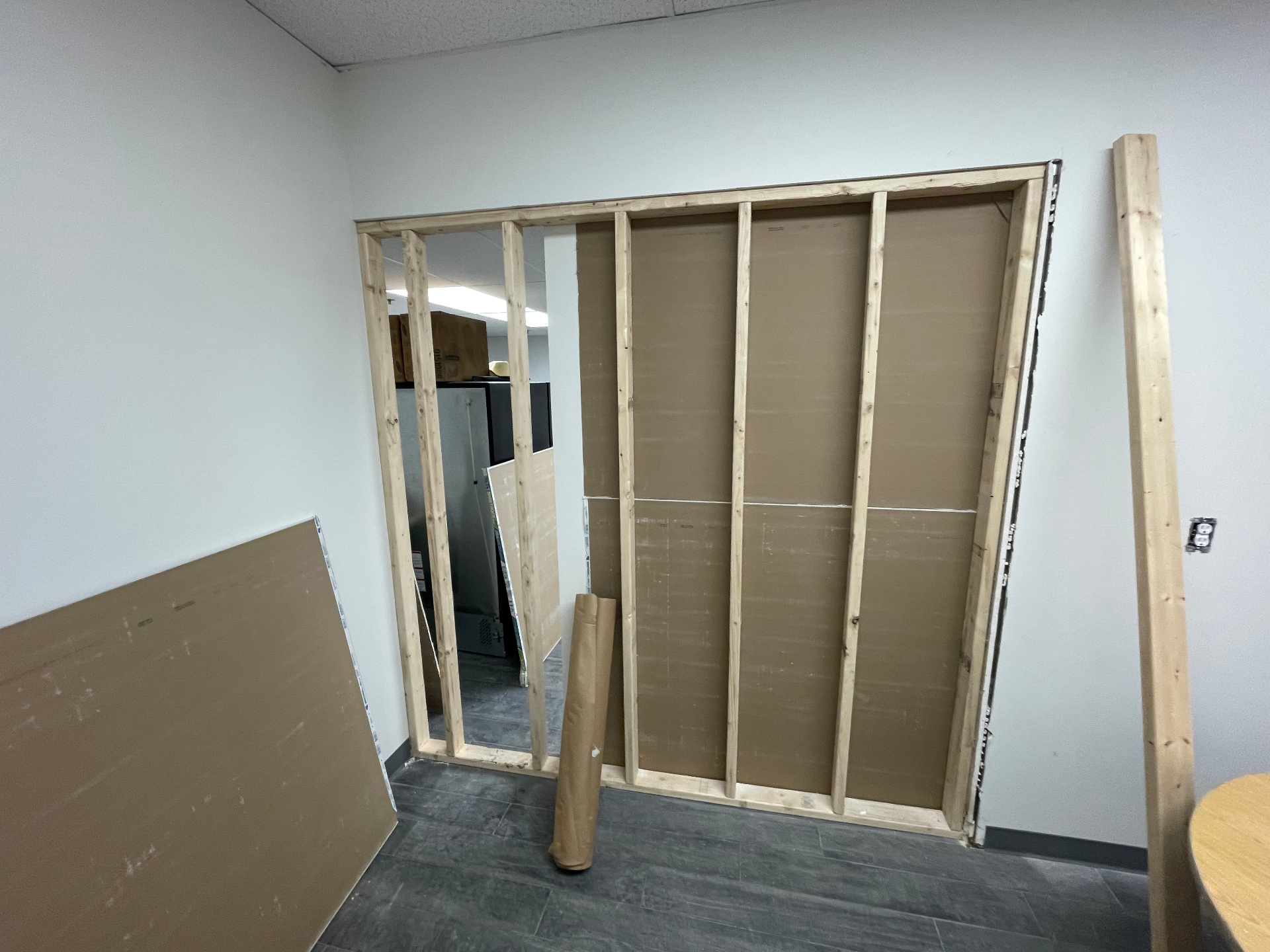 Office buildout with framed doorway and drywall panels staged for installation