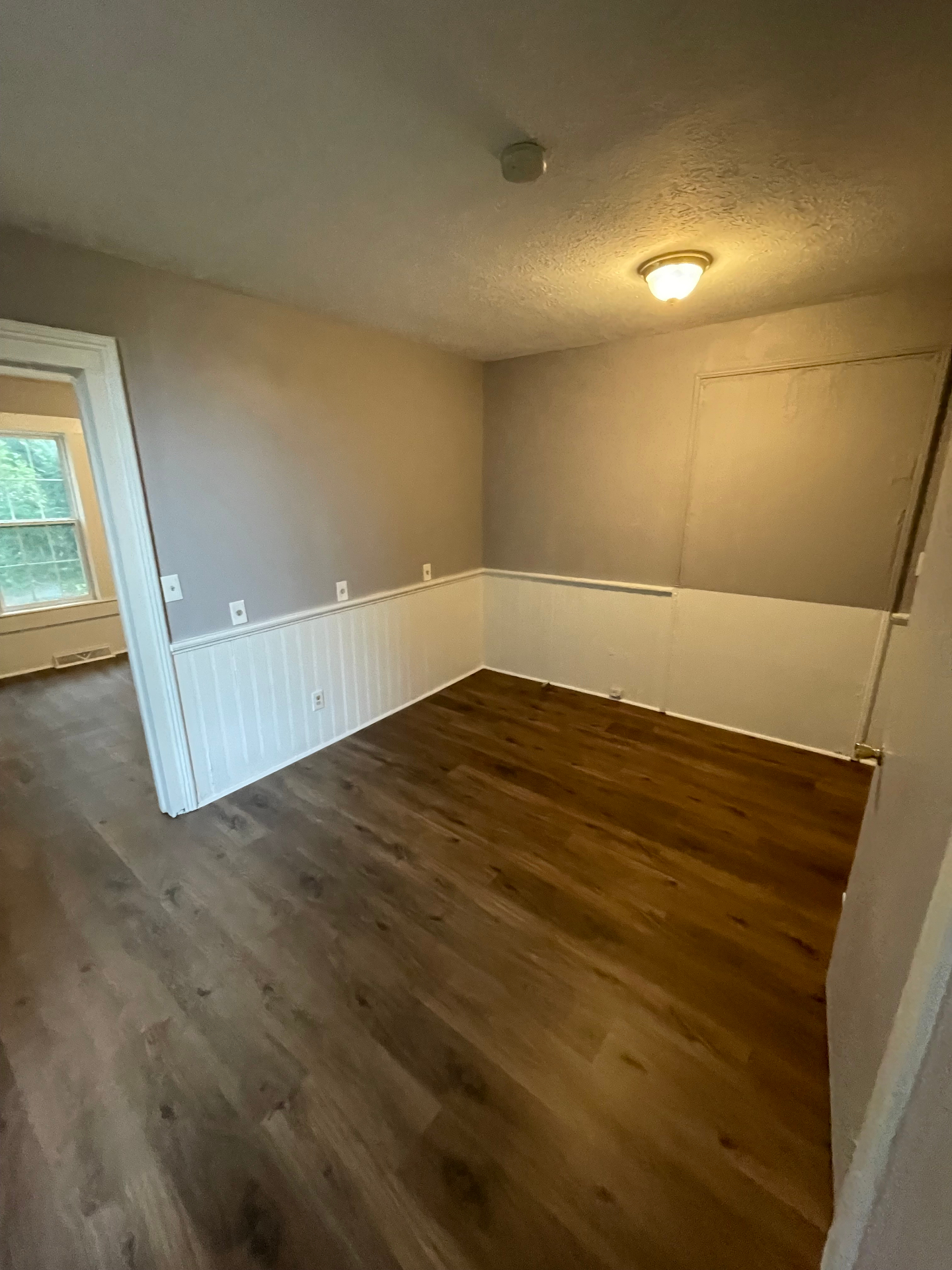 Bedroom with new luxury vinyl plank flooring and beadboard wainscoting